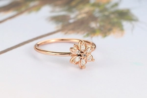 Detail of rose gold flower ring featuring marquise-cut zircons on a slender band