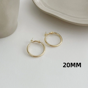 Detailed view of 20mm gold hoop earrings with minimalist high-polished finish