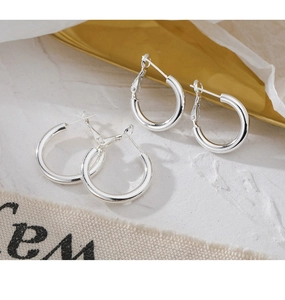 Detailed macro view of minimalist 925 silver hoop earrings with lever-back closure