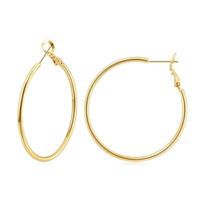 Close-up of polished gold large hoop earrings with needle clasp on white background