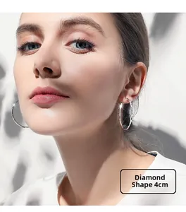 Close-up of 4cm faceted silver hoop earring on model with elegant light and shadow
