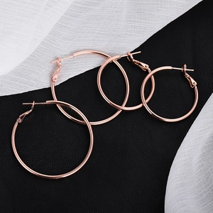 Polished rose gold 925 silver hoop earrings in two sizes on elegant black leather background