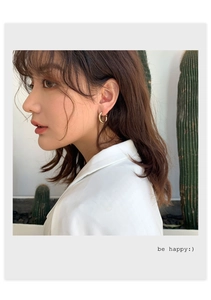 Close-up of elegant gold hoop earrings worn by a model with a stylish aesthetic