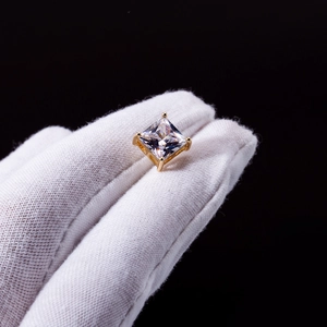Macro detail of square-cut zircon earring with classic gold four-claw setting