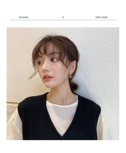 Close-up of elegant gold hoop earrings worn by a model in casual chic attire