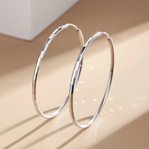 Polished silver S925 hoop earrings with geometric diamond cut pattern for women
