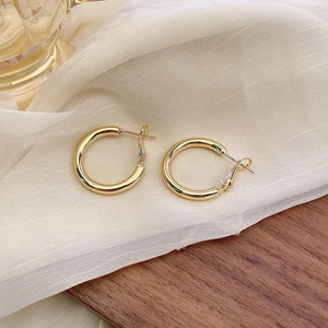 Elegant 925 sterling silver needle gold hoop earrings on a minimalist wooden surface