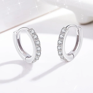 Macro detail of 925 silver hoop earrings with micro-paved sparkling zircon stones