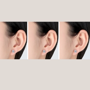 Classic round cubic zirconia stud earrings in sterling silver shown on model's earlobe