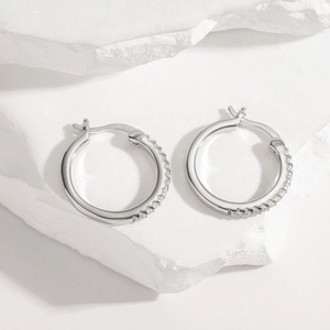 S925 sterling silver hoop earrings with white zircon stones on white stone block