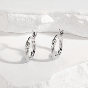 Macro shot of minimalist S925 sterling silver hoop earrings with clear 925 hallmarks