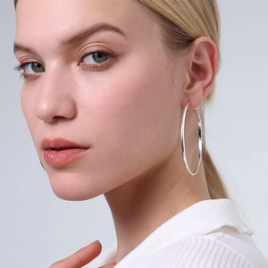 Polished silver 3mm wide hoop earrings with 925 silver needles on a female model
