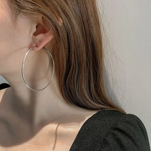 Model wearing large 3mm wide polished silver hoop earrings for a minimalist look