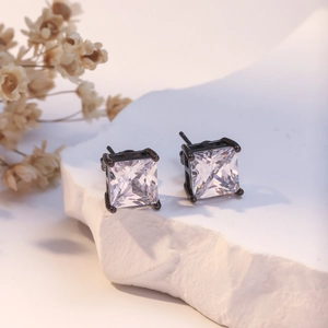 Square princess cut zircon stud earrings with black metal claw setting on a stone
