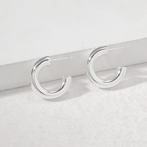 Macro shot showing S925 hallmark on polished silver hollow C-shaped stud earrings