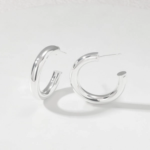 Detailed view of polished silver C-shape hoop earrings with S925 engraved stamp