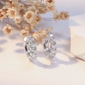 Silver chunky hoop earrings with cubic zirconia inlay on elegant stone background