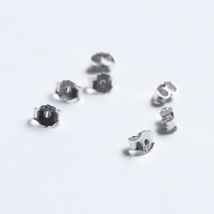 Detail of 925 sterling silver butterfly earring backs with visible metal hallmarks