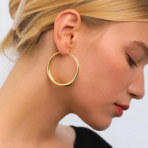 Polished chunky gold hoop earrings for women shown on model for a trendy fashion look