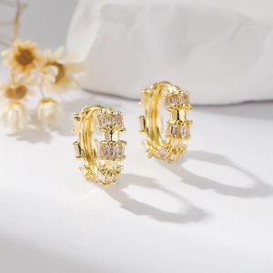 Macro shot of gold hoop earrings featuring double rows of baguette zircon stones