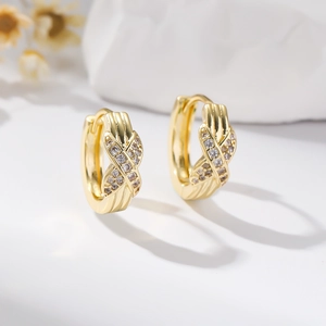 Macro shot of 18K gold hoop earrings with pavé criss-cross micro-set zircon detail
