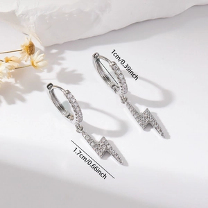 Detailed view of silver hoop earrings with lightning bolt pendants and white cubic zirconia