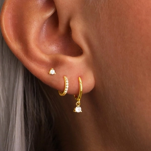 Elegant gold-plated S925 earrings set with brilliant zircons on a model's ear