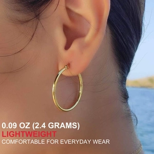 Close-up of lightweight gold hoop earring worn by a model with detailed weight parameter