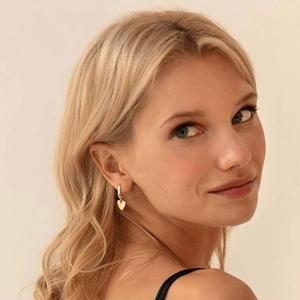 Polished gold heart drop earrings on model, stylish S925 silver needle hoop design
