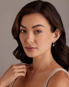 Detailed view of gold plated star stud earrings with zirconia and fine link chain