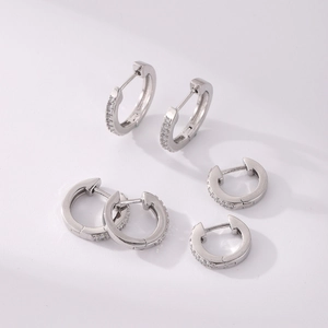Detailed view of three pairs of silver pave cubic zirconia hoop earrings on white