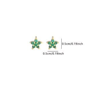 Detailed view of tiny 5mm gold star stud earrings with green zircon stones