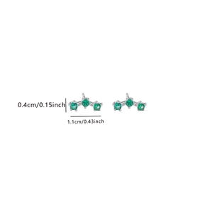 Detail of three-stone gradient stud earrings featuring green cubic zirconia and silver metal