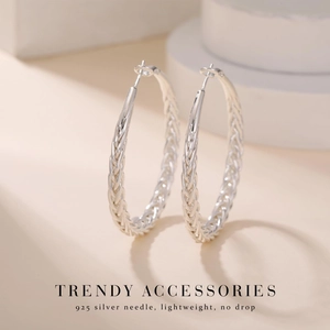 Detail shot of silver braided hoop earrings featuring a 925 silver needle and woven texture