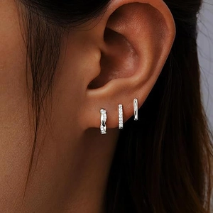 Macro view of three silver-plated earrings including twisted pavé and smooth hoop styles