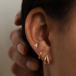 Elegant gold S925 silver stud earrings with zircon flower petals on female model ear