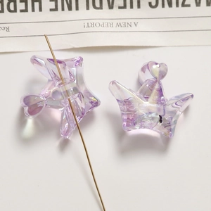 Macro shot of purple translucent iridescent crown and star charms for jewelry making
