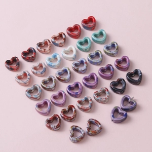 Macro view of heart-shaped ceramic beads with colorful marble glaze for DIY jewelry