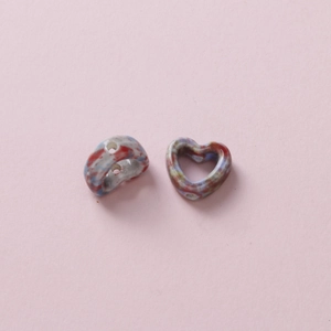 Macro detail of camouflage ceramic heart beads with holes for DIY jewelry making