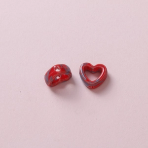 Macro shot of red and blue marble textured heart-shaped ceramic beads for DIY jewelry