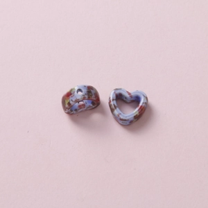 Close-up of heart and ring-shaped ceramic DIY beads with retro speckled blue glaze