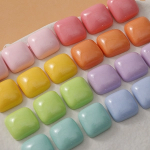 Macro shot of colorful 15mm square resin beads in pastel macaron shades for DIY jewelry making