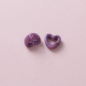 Close-up of purple camouflage heart-shaped ceramic beads showing DIY threading holes
