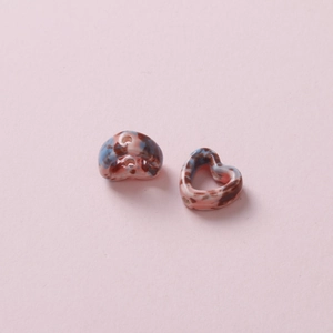 Macro view of handmade camo heart ceramic beads with marble texture for DIY jewelry
