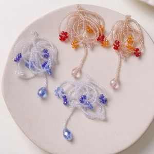 Detailed view of handmade beaded floral charms with colorful teardrop crystal pendants