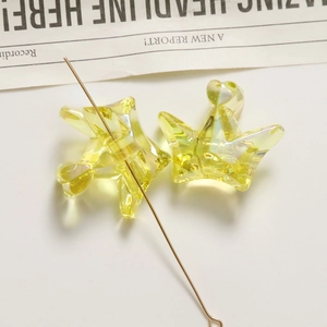 Macro shot of yellow transparent acrylic crown charms with hole for DIY jewelry making