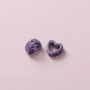 Macro shot of two heart-shaped ceramic beads with purple and blue marble pattern for DIY