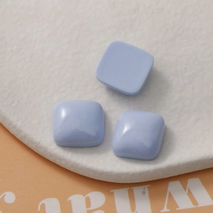 Detailed macro view of light blue square resin charms with smooth glossy macaron finish