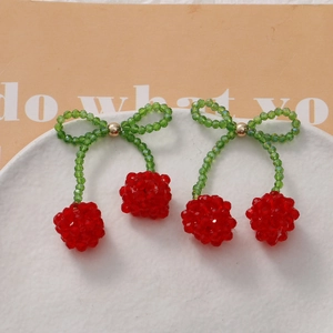 Detailed view of handmade beaded cherry pendants with red crystal beads and green leaves