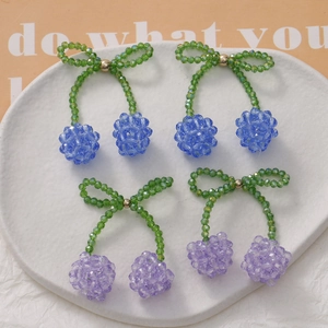 Detail of handmade beaded cherry charms with crystal beads and bowknot for DIY jewelry
